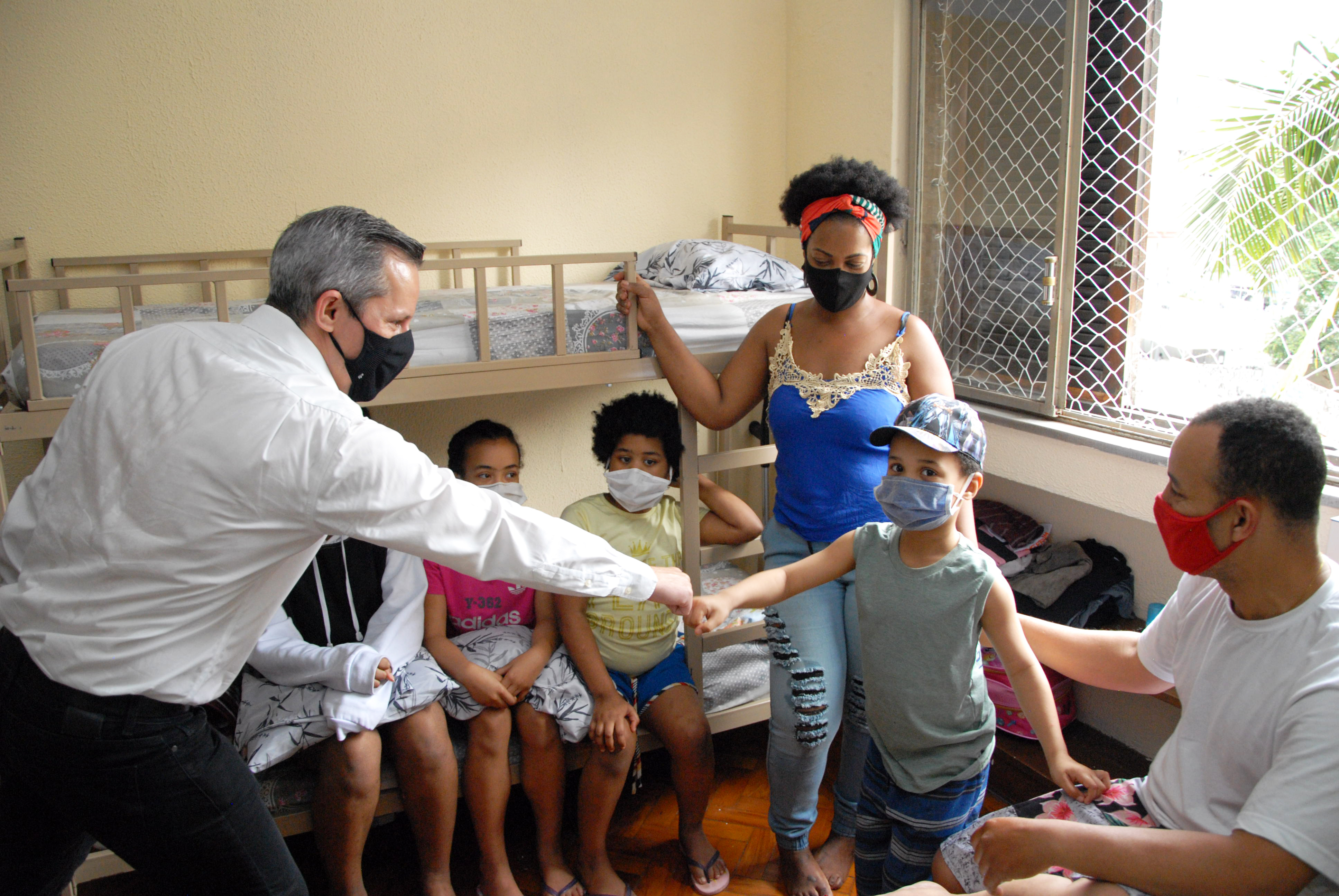 Presidente da Cohab, Luigi Lazzuri Neto, cumprimentando a criança na nova residência de sua família