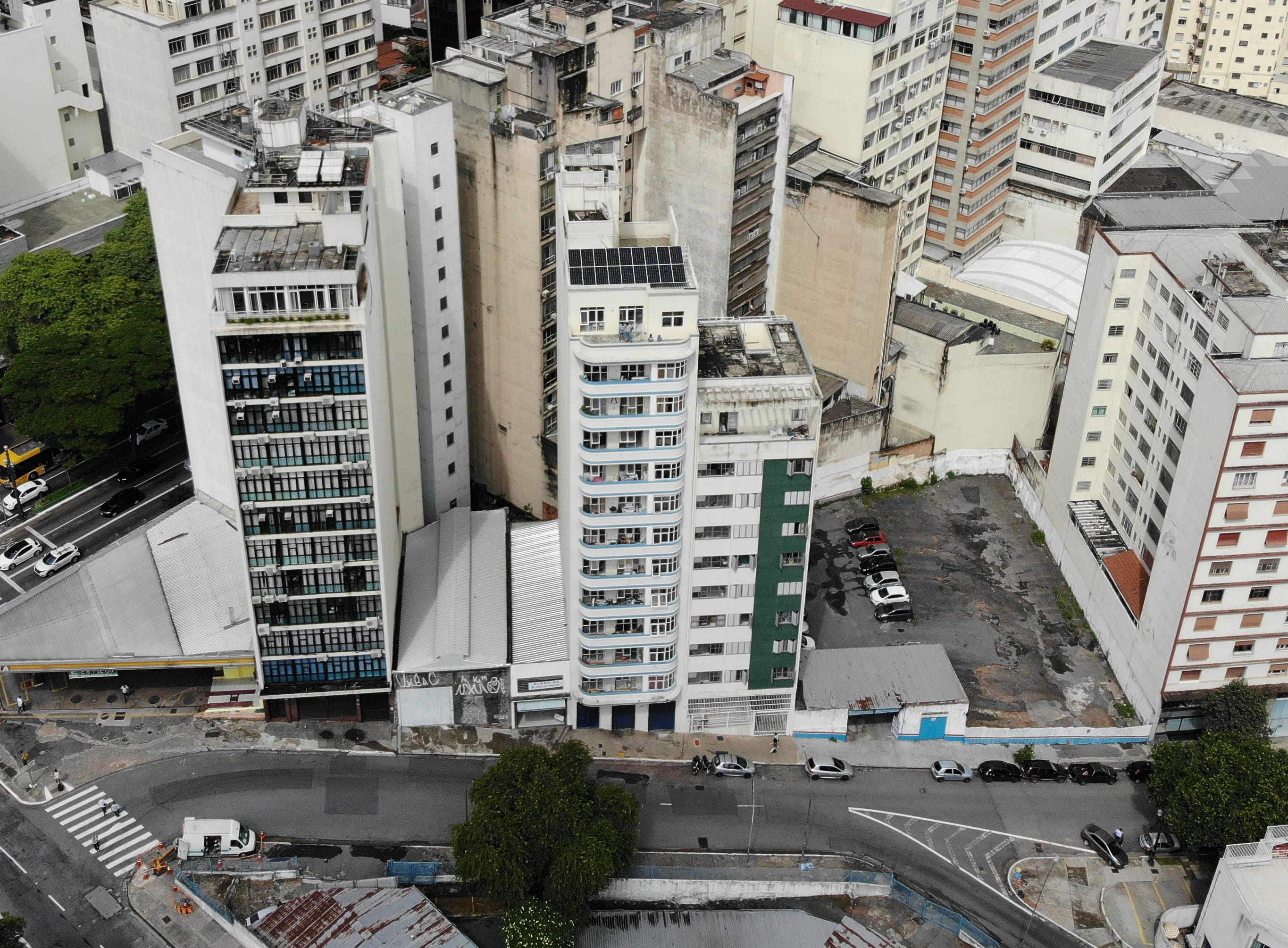 Foto aérea do empreendimento, com os painéis já instalados, mostrando a rua e o arredor que cerca o conjunto habitacional