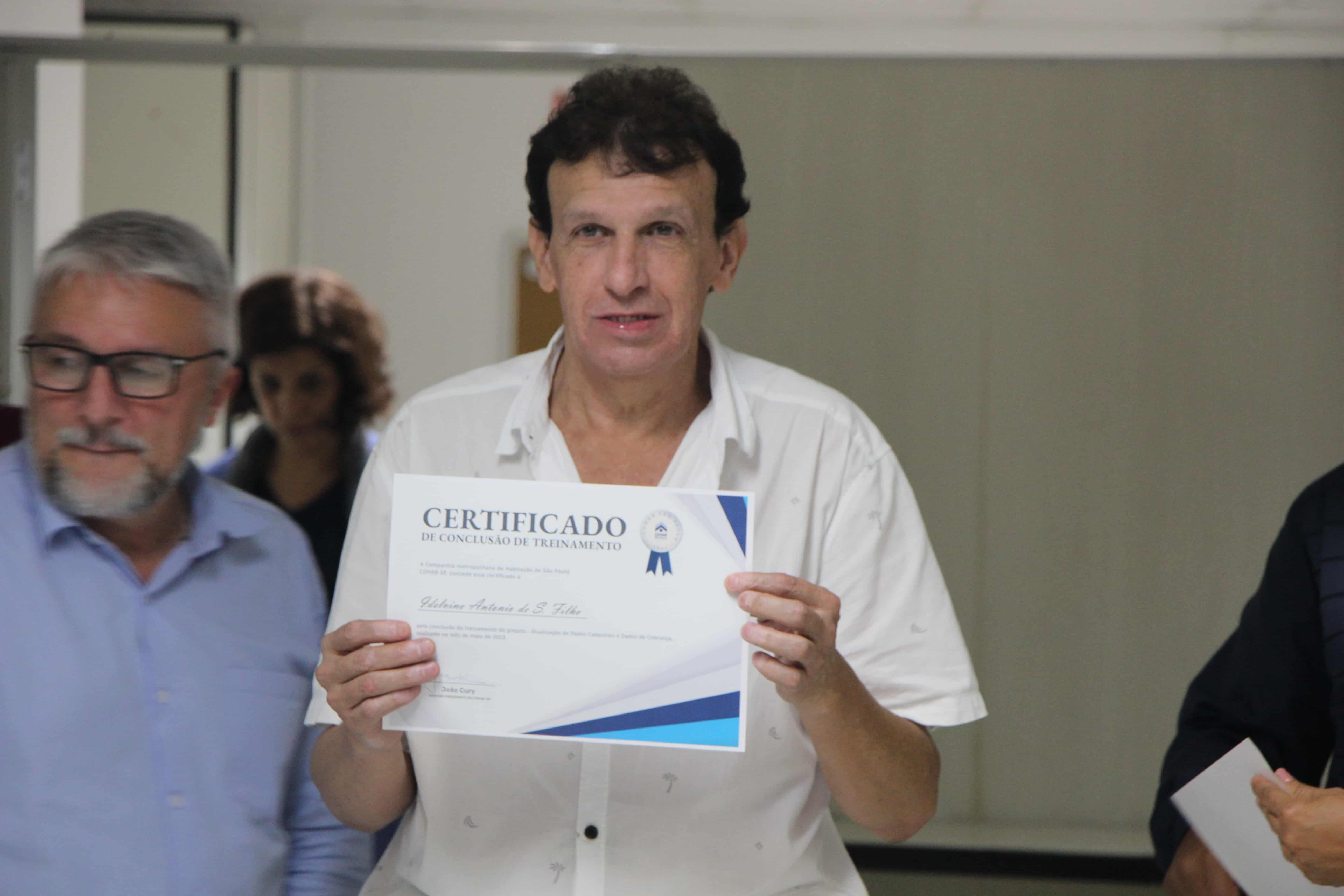 Funcionário da Cohab com seu certificado do treinamento de atendimento. 