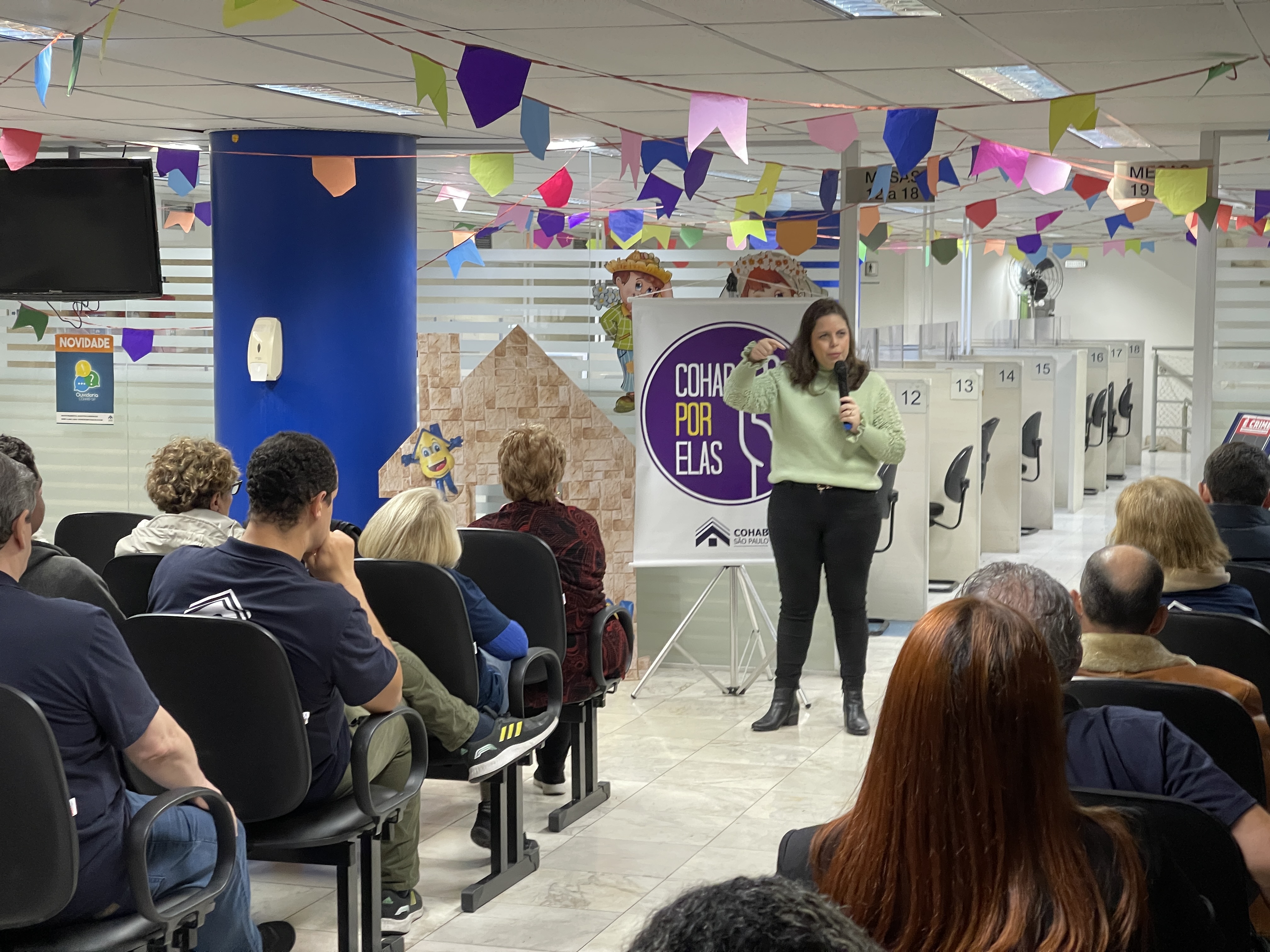 A psicóloga Ana Carolina Sampaio Fernandes com o Programa Cohab Por Elas dando treinamento com seus colaboradores para capacitá-los a orientar mulheres que possam estar sofrendo algum tipo de violência. 