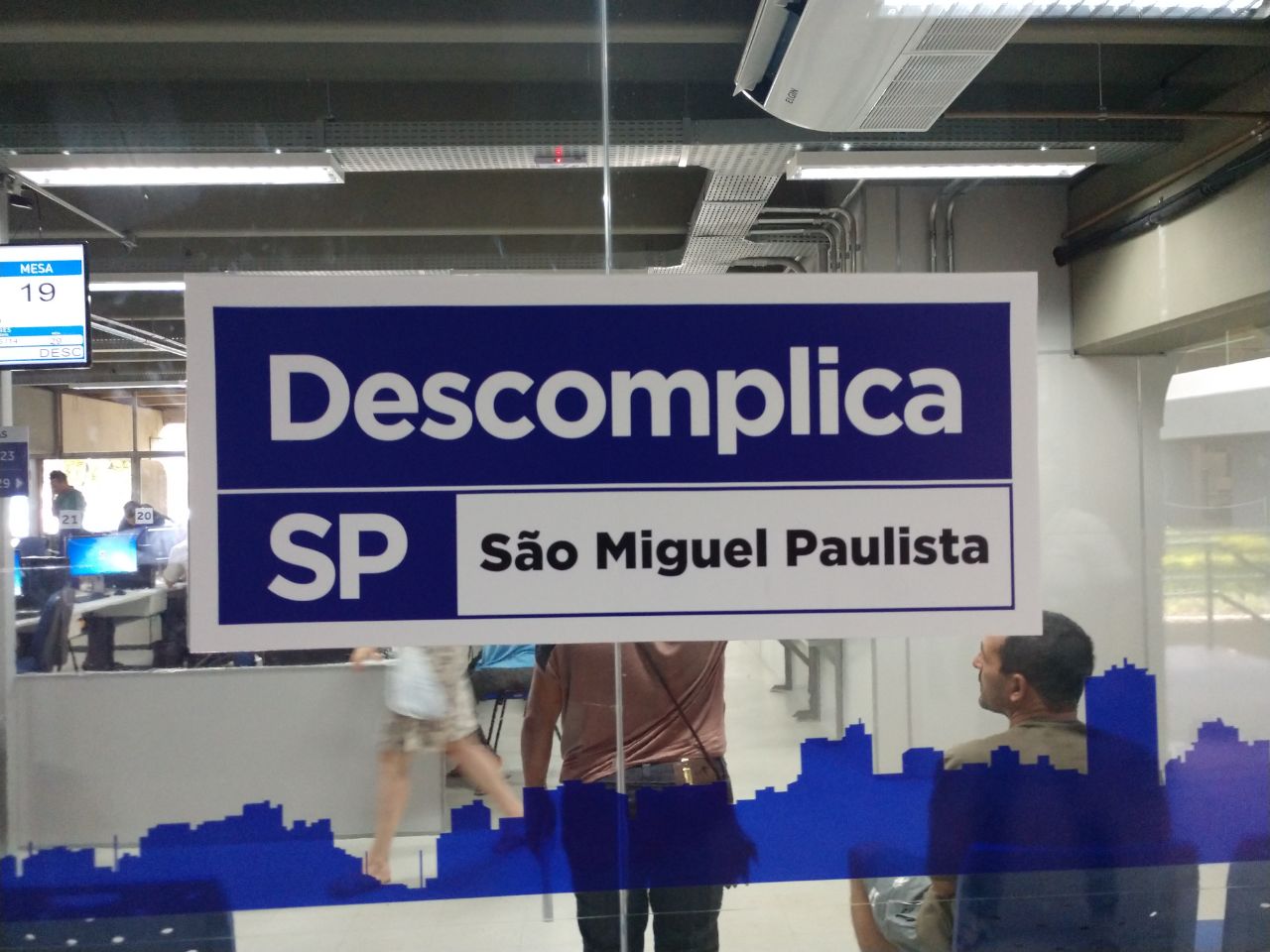 A imagem, é a placa do Descomplica SP São Miguel Paulista no vidro do estabelecimento.