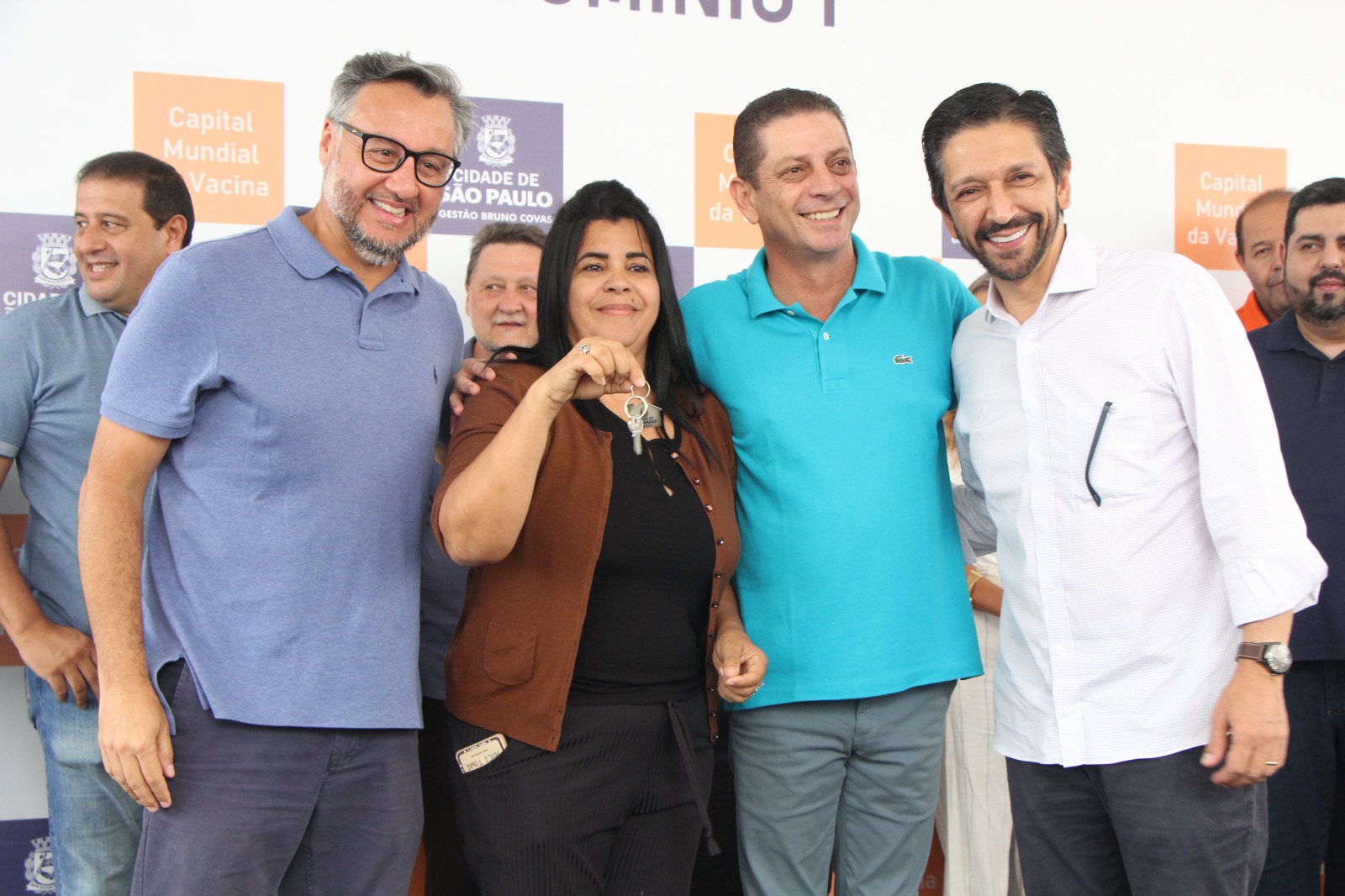 Diretor Presidente da Cohab-SP, Secretário de Habitação João Farias e Prefeito Ricardo Nunes juntos a munícipe segurando as chaves