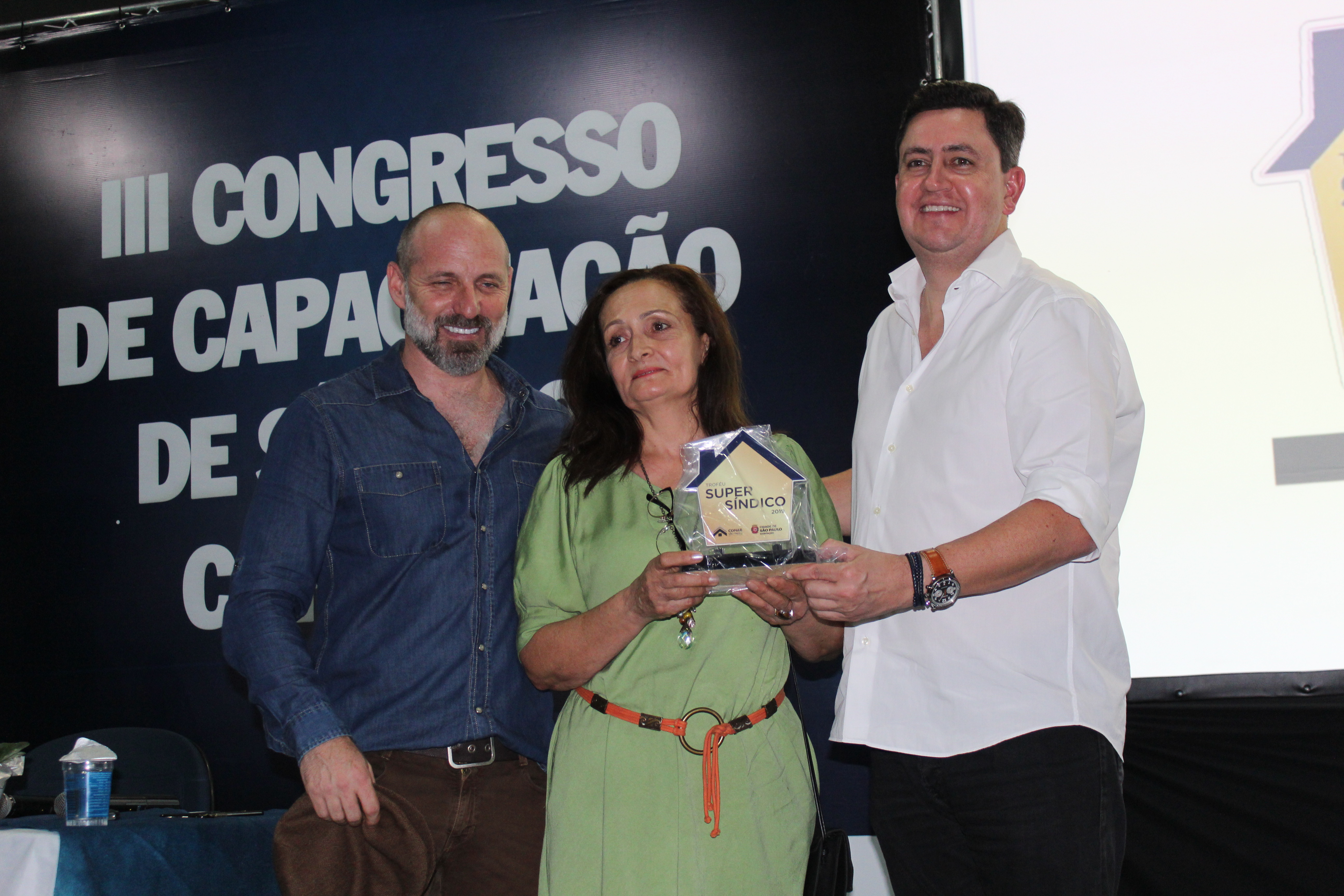 Na foto, da esquerda pra direta está Marcio Rachkorsky, no meio com o troféu a sindica Ana Maria Dantas de Carvalho e ao lado dela está o presidente da Cohab Alex Peixe. 